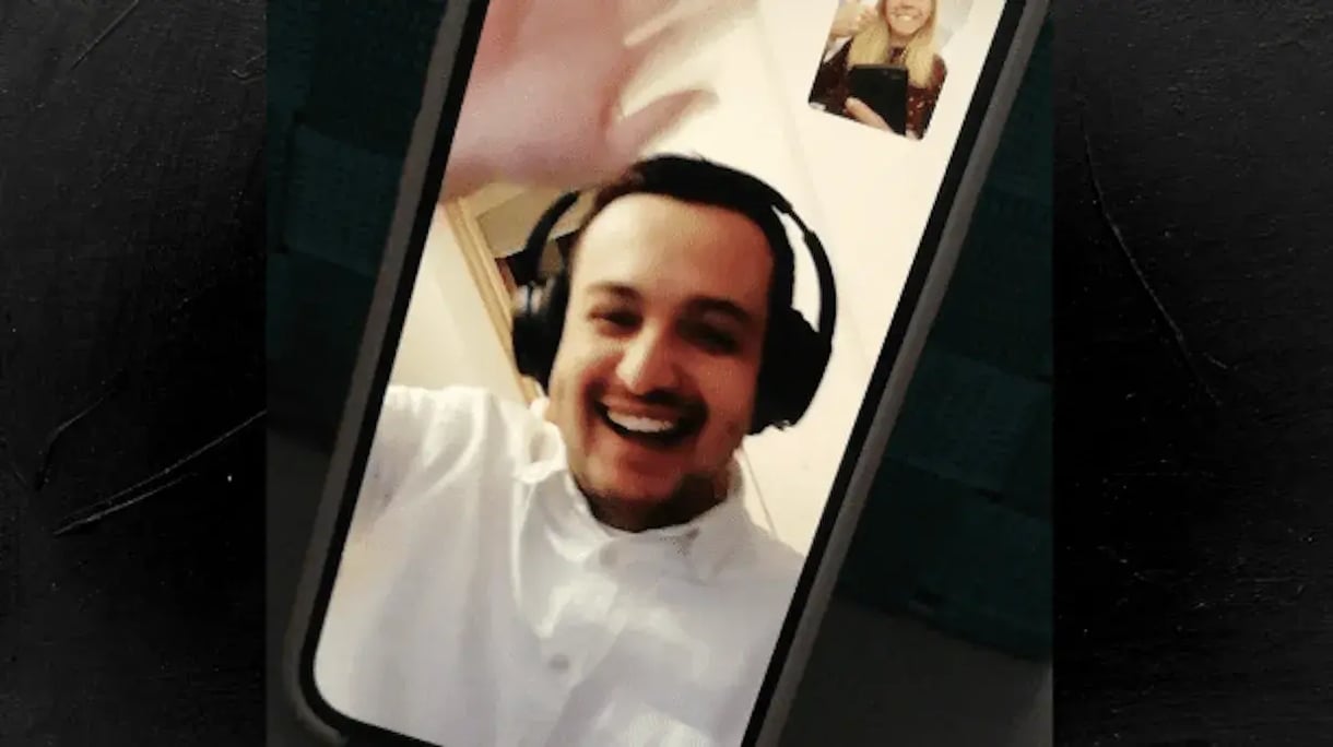 Een man zwaait op facetime
