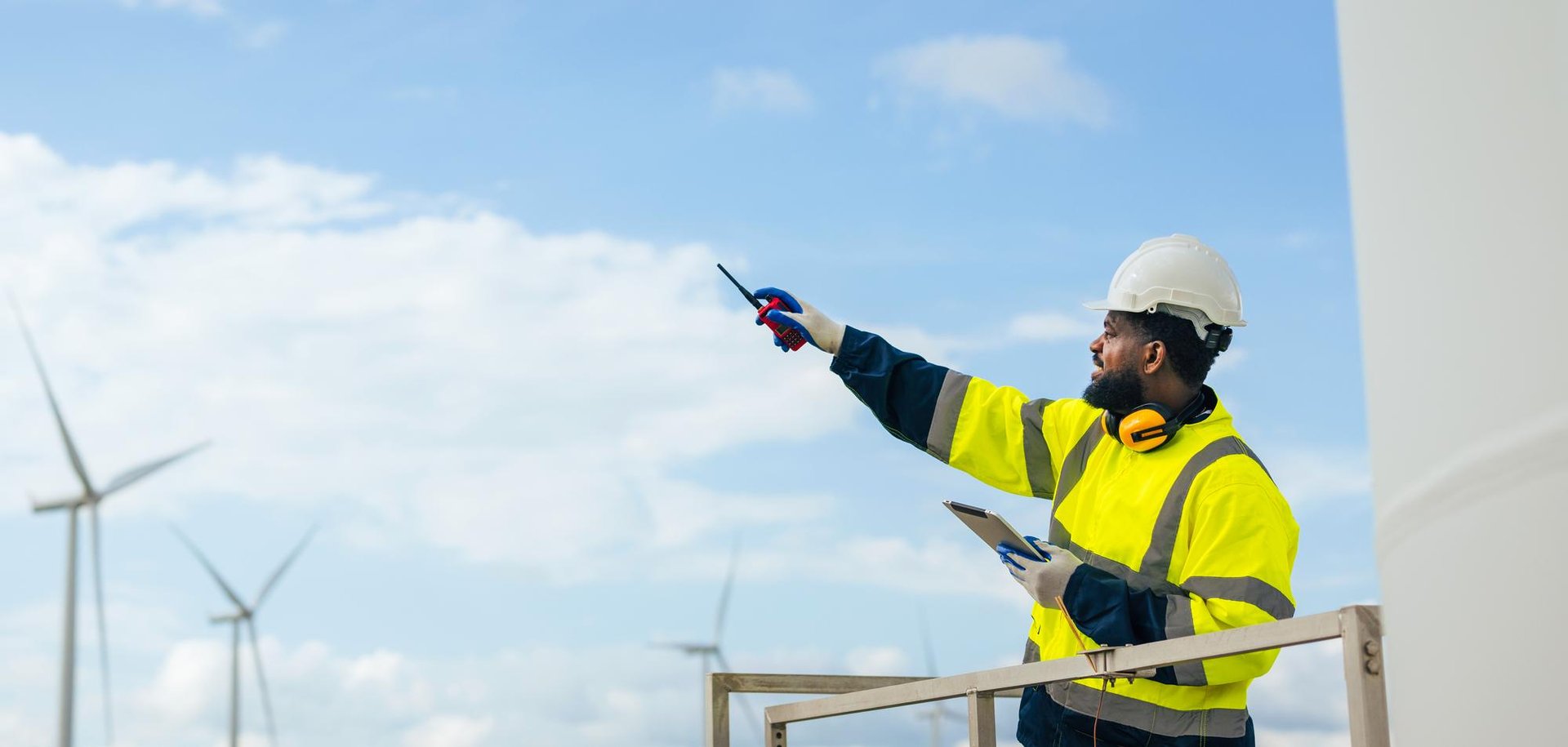 Energy & utilities medewerker die op een windmolen staat