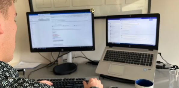 Iemand werkt met twee schermen