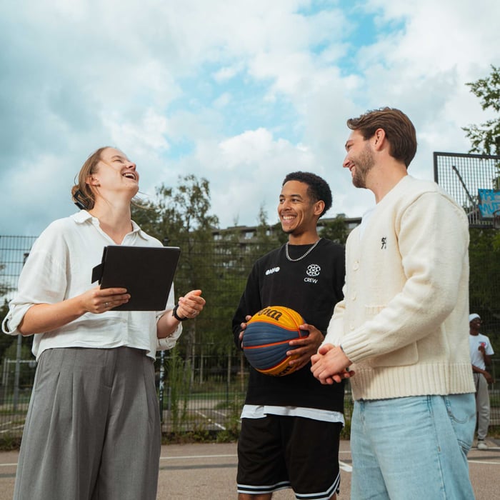 Drie mensen op het basketbalveld