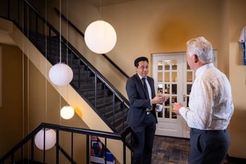 Two men standing in a modern staircase