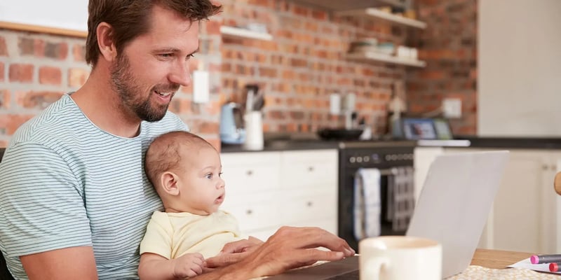 Man met een baby kijken naar een laptop