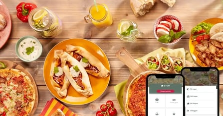Tafel vol met eten en een mock up van de Pure Ingredients app