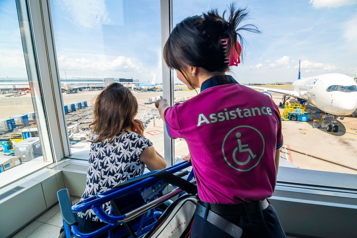 An airport employee showing a person with a disability the tarmac