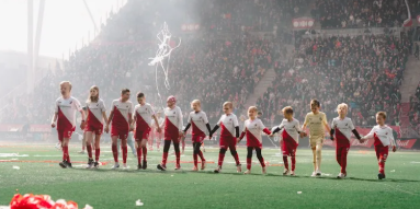 Kinderen lopen in een rij over het voetbalveld van Conclusion.