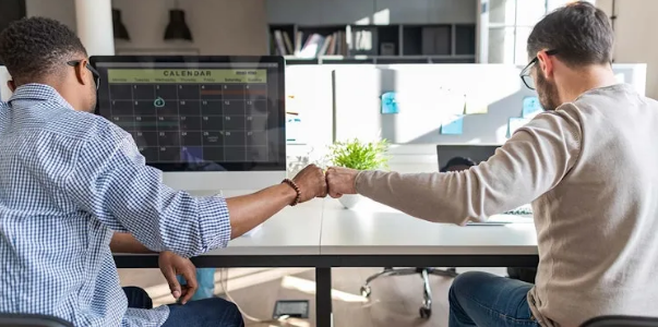 Twee collegas geven elkaar een box