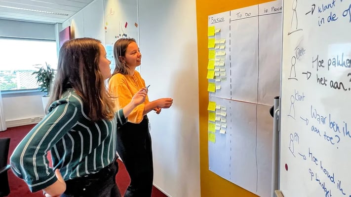 Twee collegas kijken naar wat sticky notes