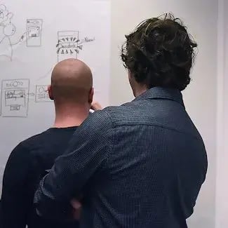 Twee collegas werken met een whiteboard 2