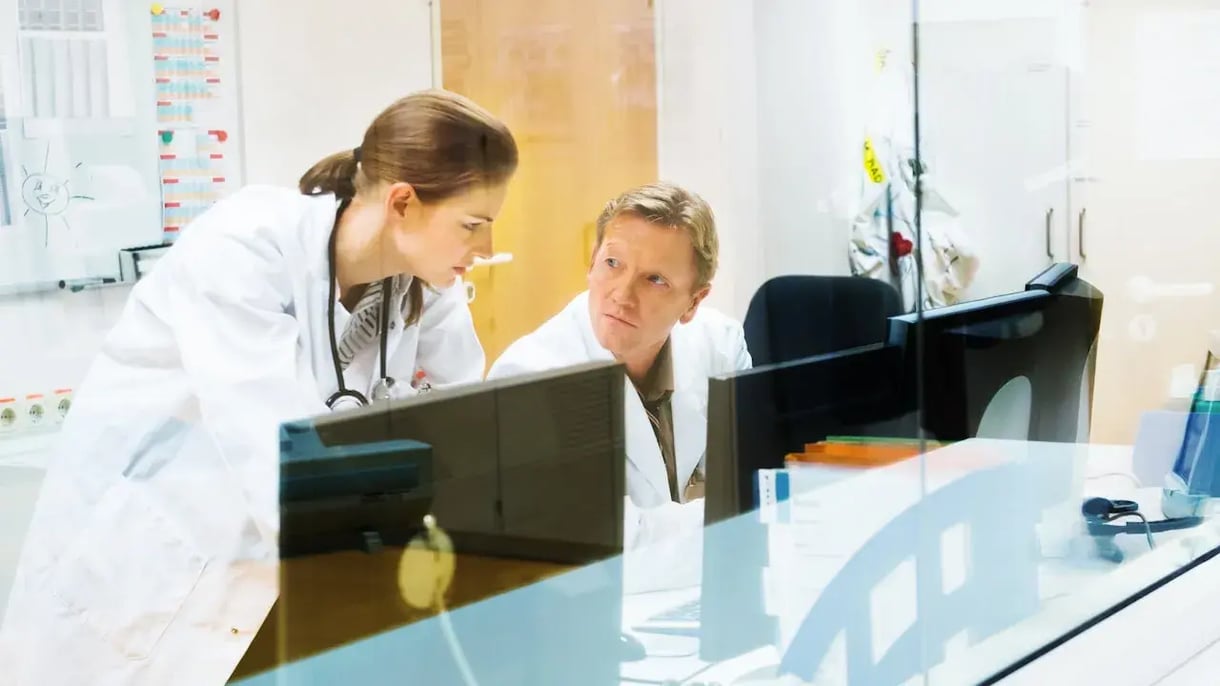 Twee doctors kijken met zorg naar een scherm