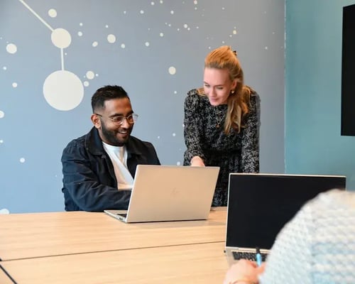 Twee mensen kijken naar een laptop