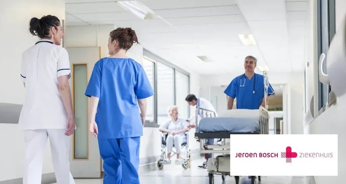 Verpleegsters lopen in een ziekenhuis met de Jeroen Bosch logo in een hoekje