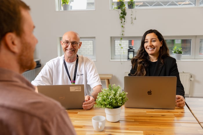 Collega's zitten aan tafel in een sollicitatiegesprek.
