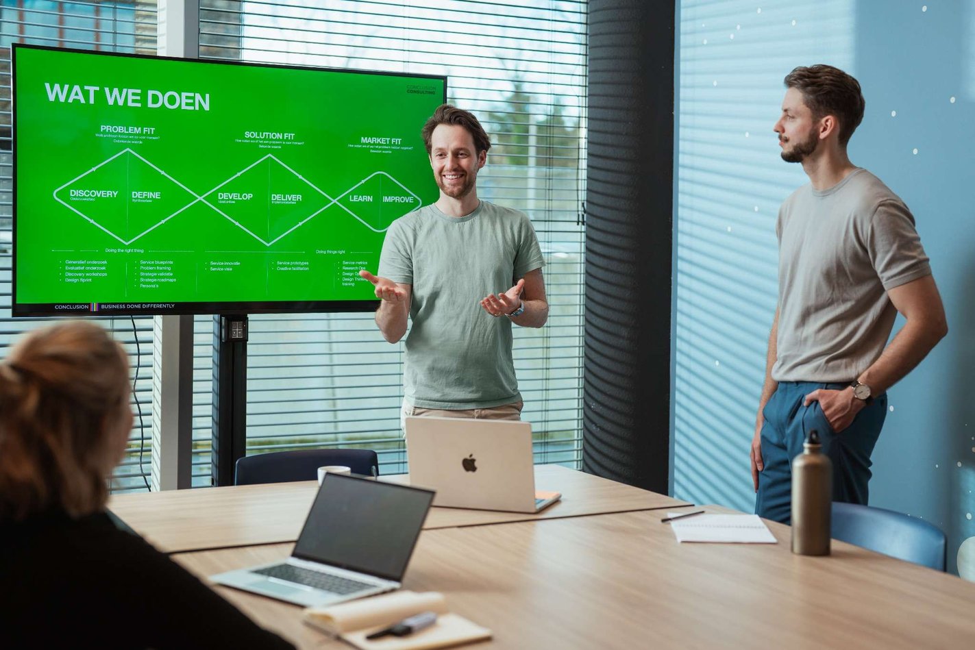Twee mannen bij een scherm geven een presentatie
