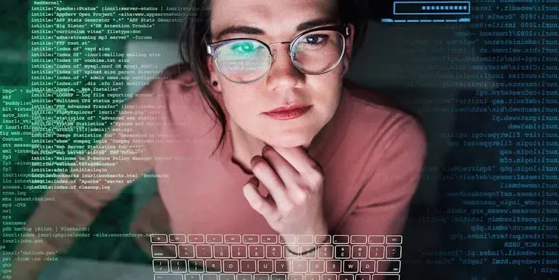 Jonge vrouw met bril die naar een scherm kijkt met een overlay met allemaal data en code erop
