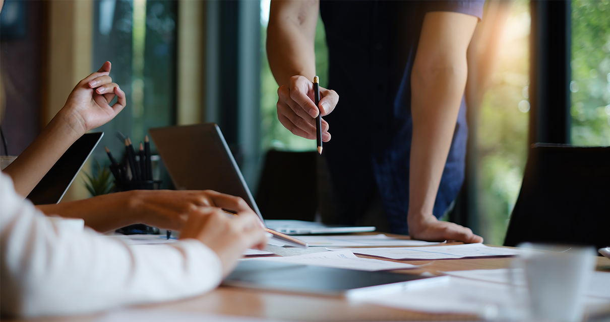 People working at a desk, faces out of frame