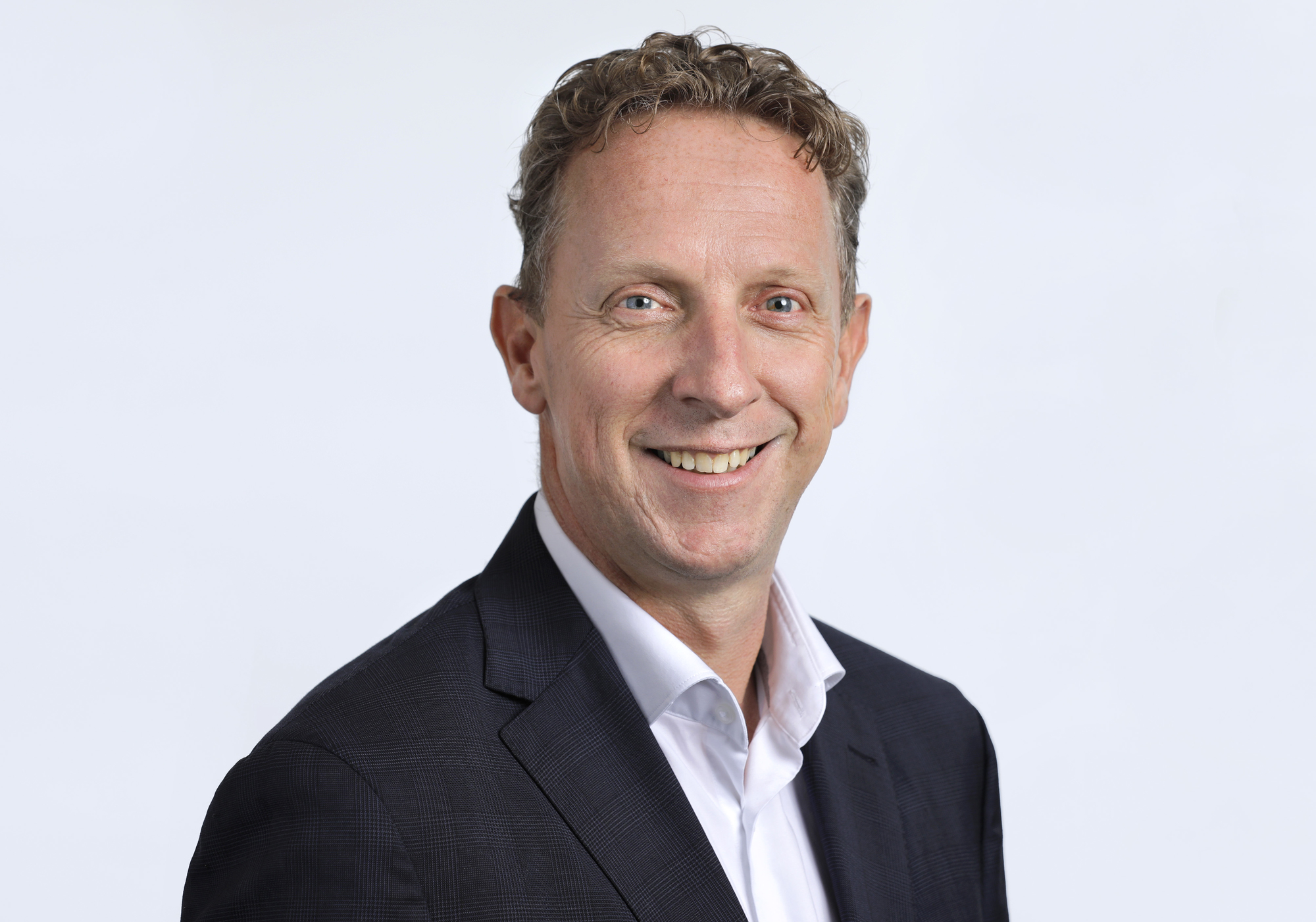 Man in suit is laughing into the camera