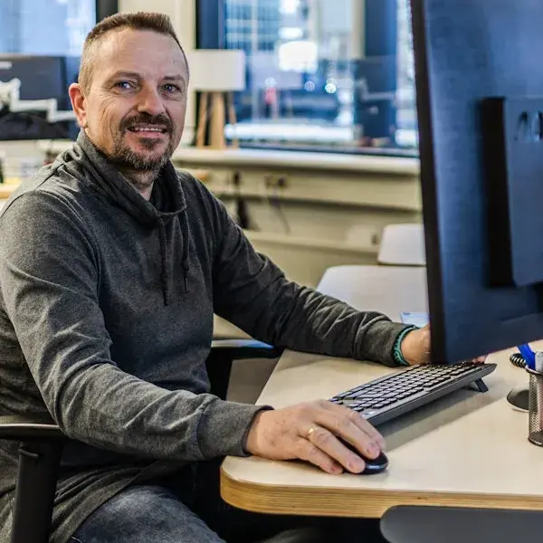 Man lachend achter zijn computer