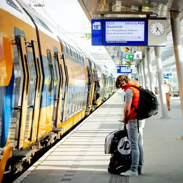 reiziger met tas die wacht op trein op perron