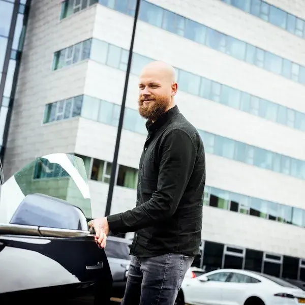 Man stapt zijn auto in.