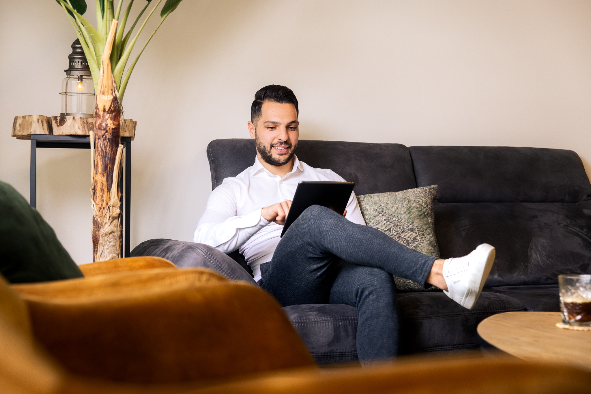 Man zit op de bank met tablet