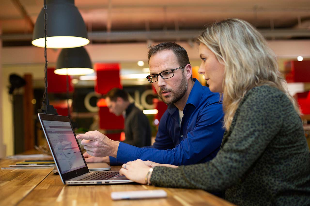 Een man en vrouw achter een laptop