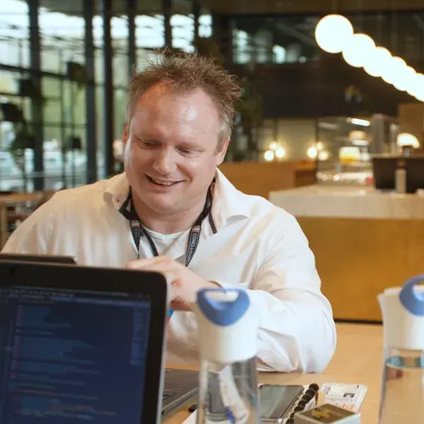 Man glimlachend achter computer