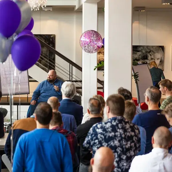 Groep mensen met paarse ballon bij een evenement