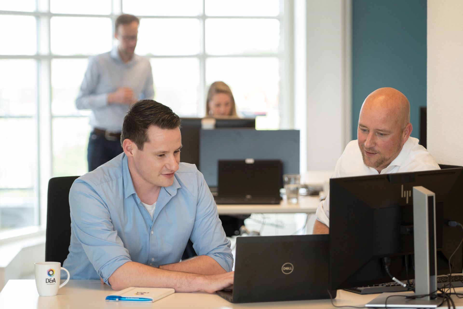 collega's overleggen achter computer