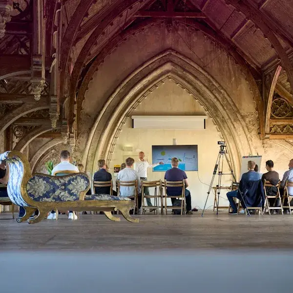 groep collega's die een presentatie bekijken in de nok van een klassiek monumentaal pand