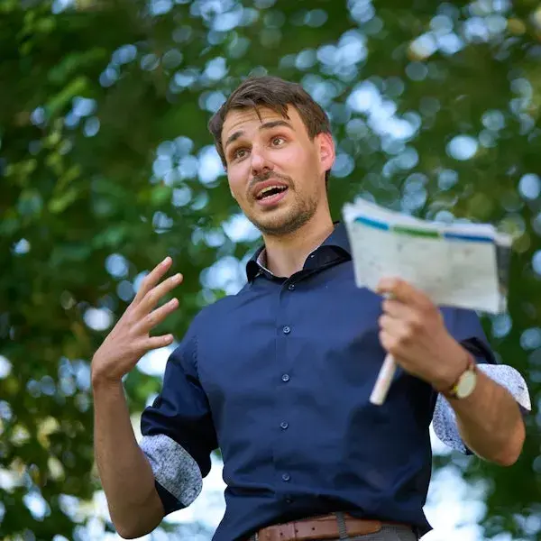 foto van man die buiten een presentatie geeft