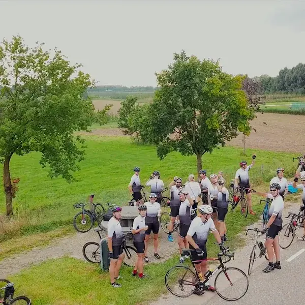 Foto van boven van een groep collega's die aan het wielrennen zijn in matchende witte shirts