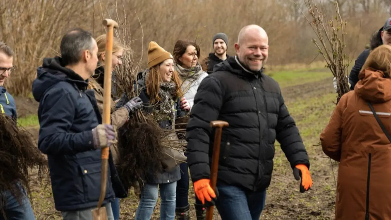 Mensen lopen in een bos met een schep.
