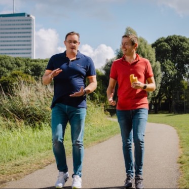 Two colleagues walking with their lunch outside.