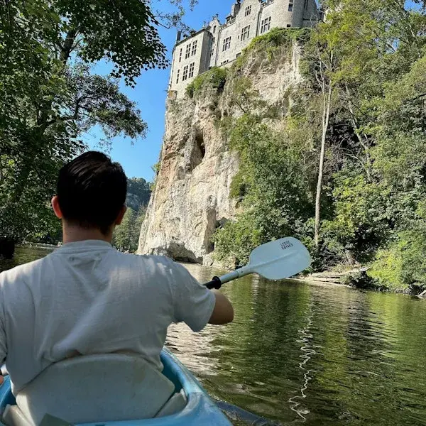 foto van een jongen van achter die buiten in de natuur in een kano zit
