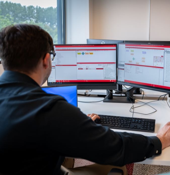 Werknemer achter computerschermen.