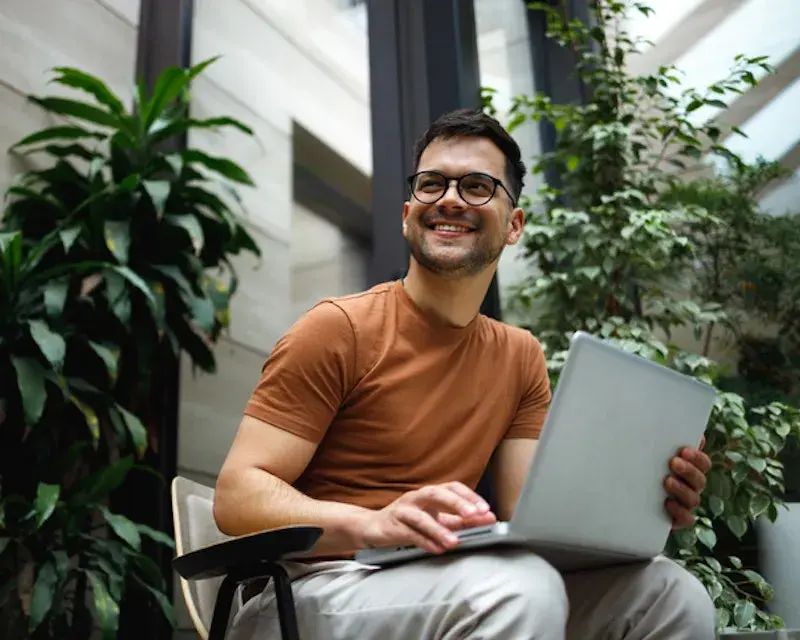 Lachende man met bril en laptop