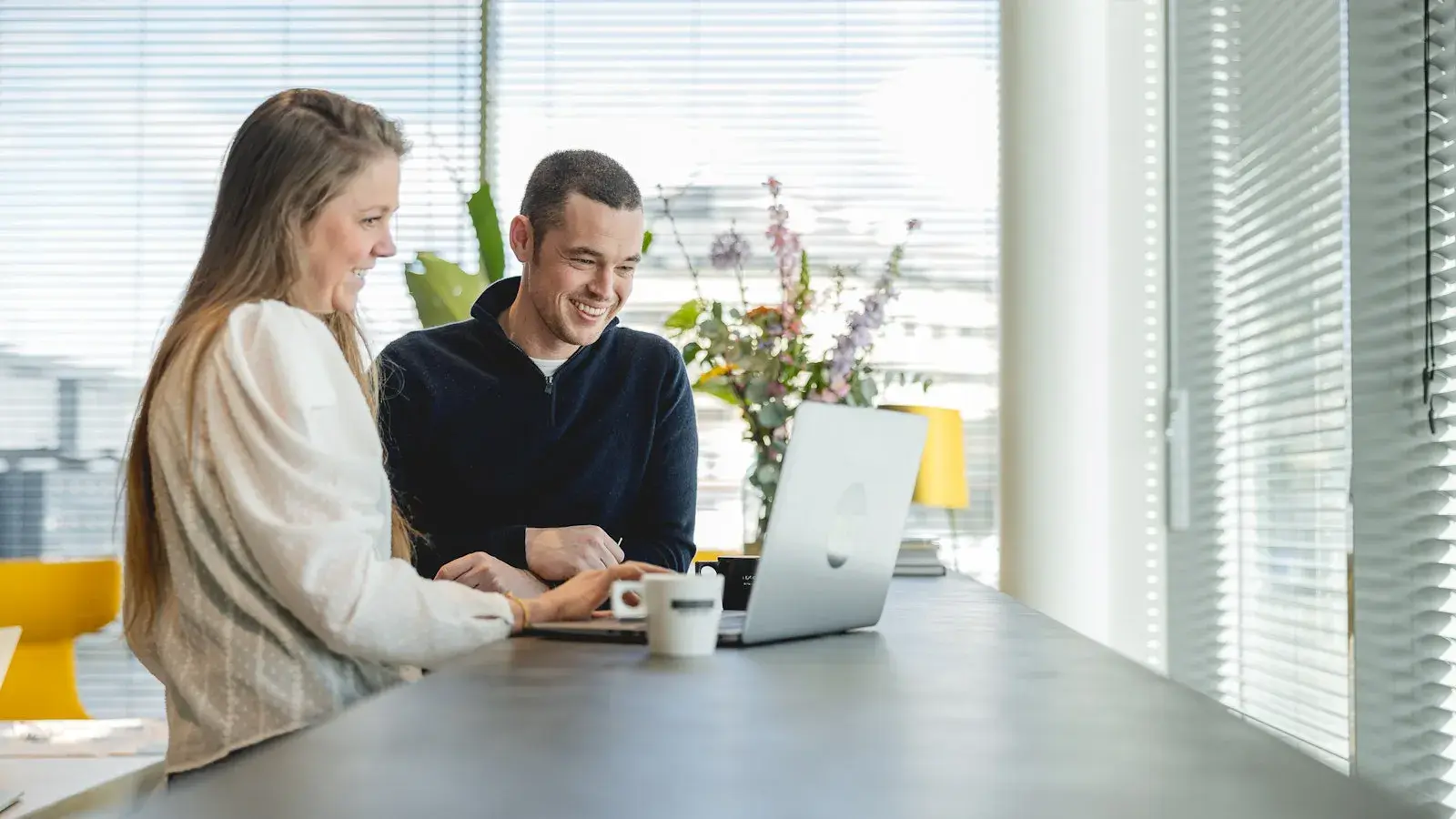 Vrouw en man kijken samen naar laptop 