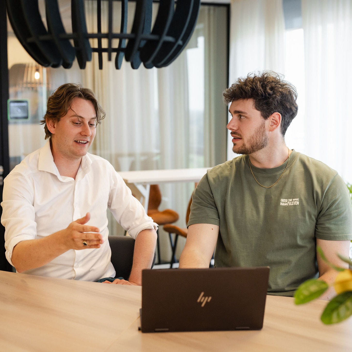 Twee consultants in gesprek aan een tafel