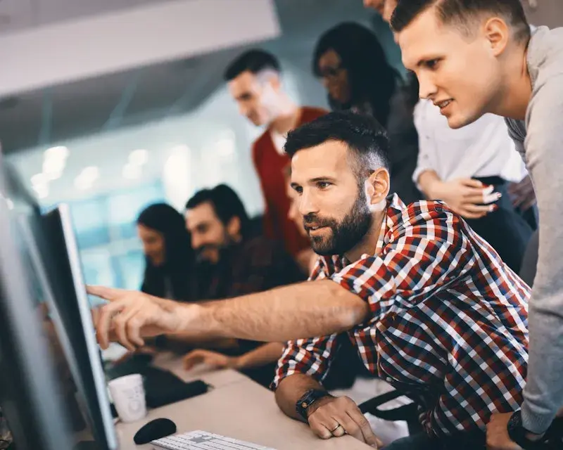 Collegas wijzen samen naar een scherm