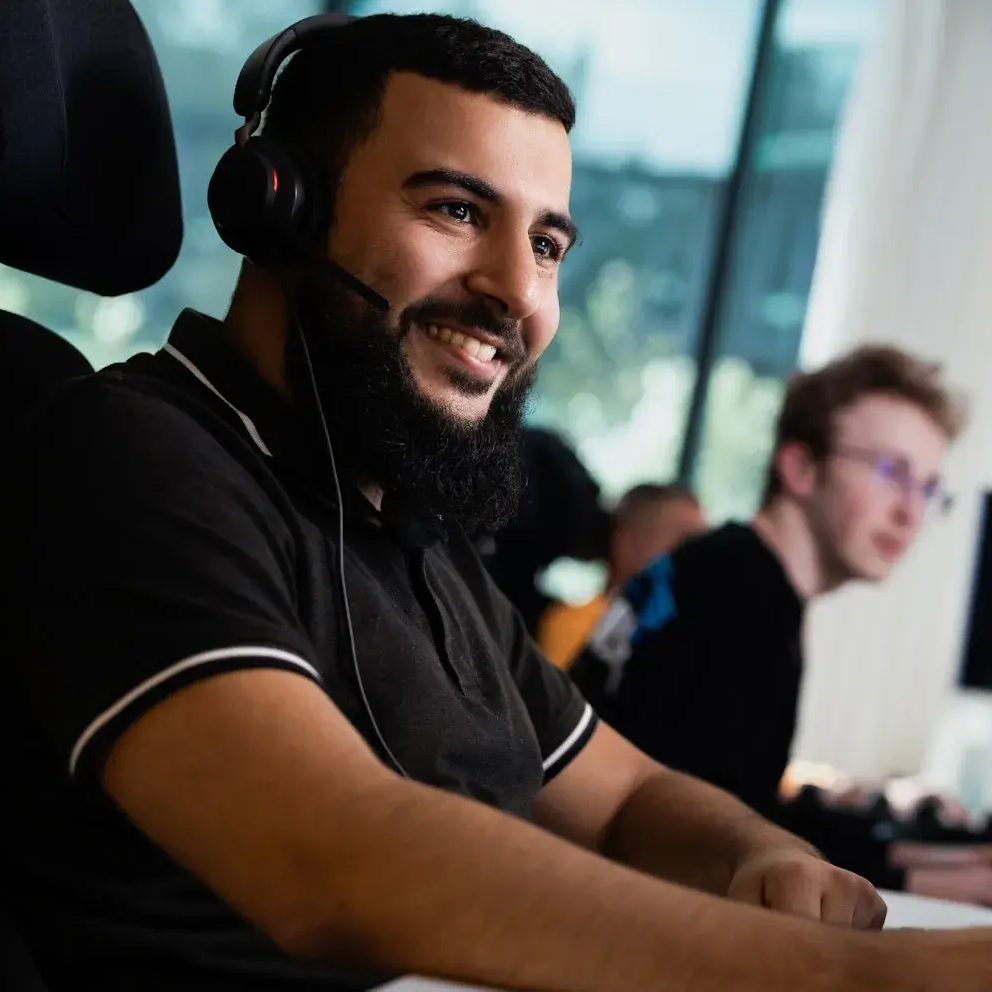 Twee collegas eentje met een headset kijken naar een scherm