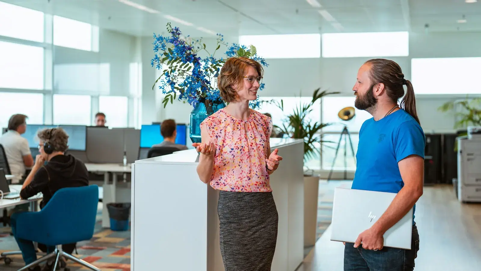 Twee collegas hebben een gesprek op kantoor