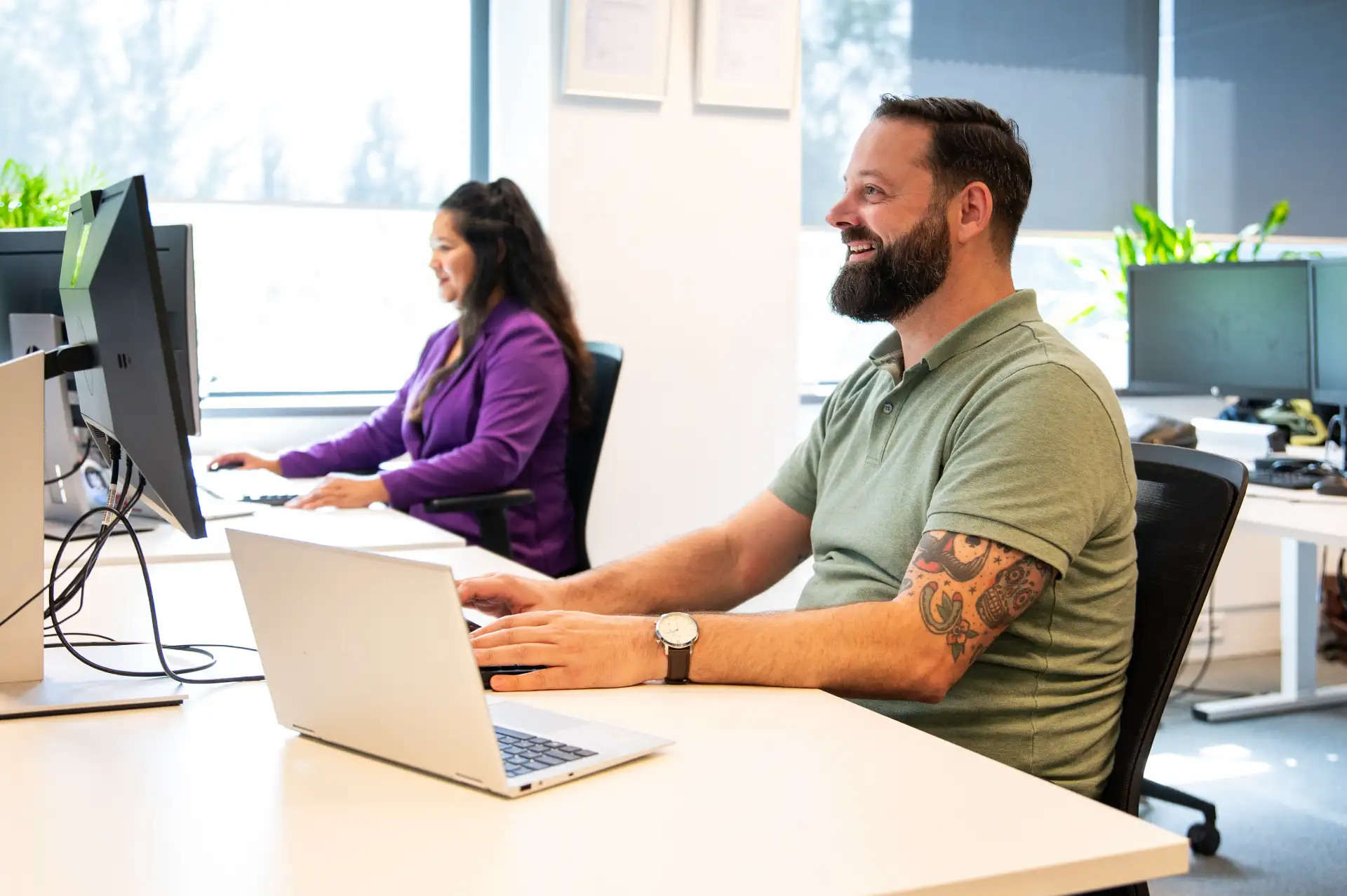 Man en vrouw aan bureau achter laptop.