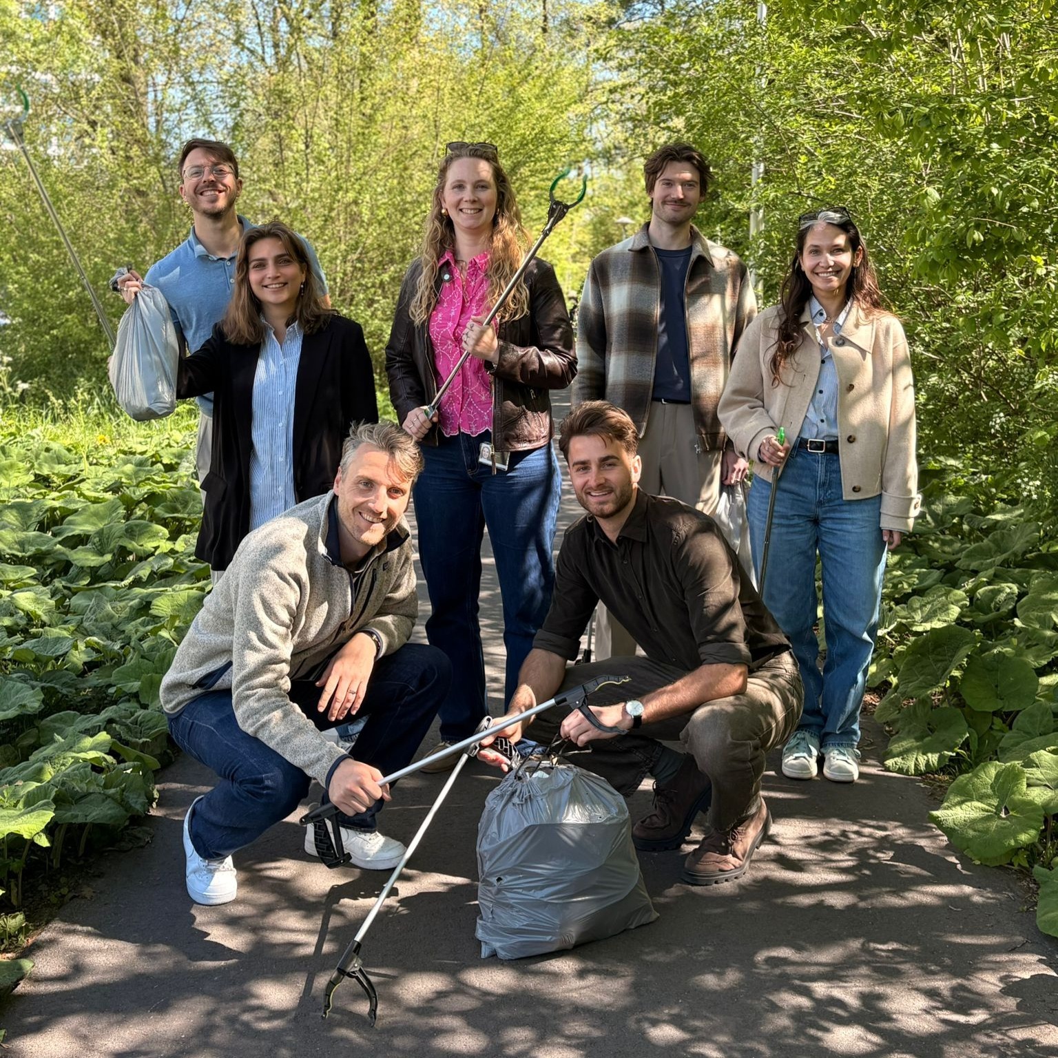Groep mensen die afval rapen en poseren voor een foto