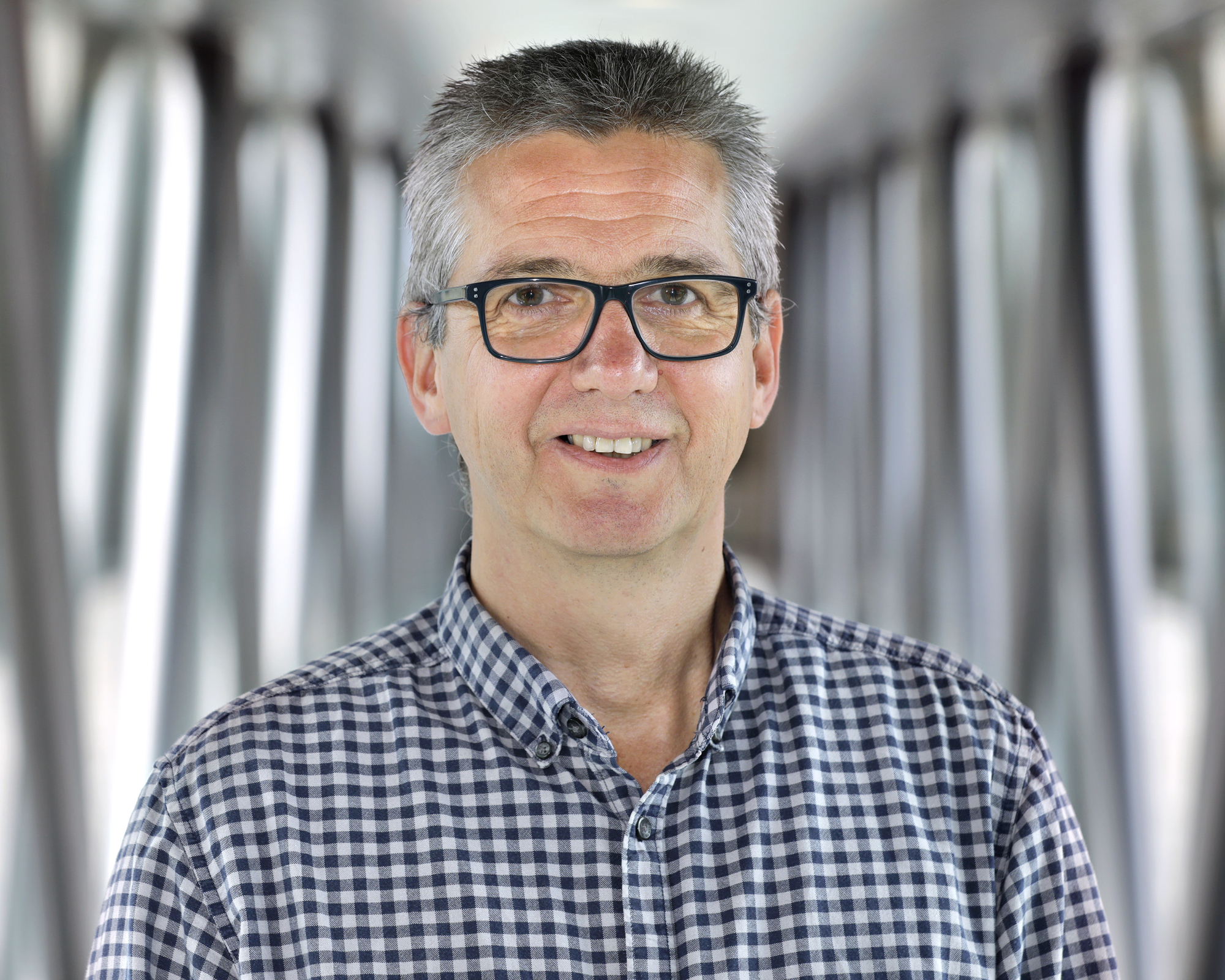 Man with glasses is laughing into the camera 